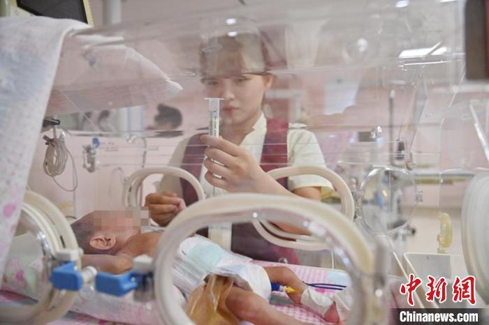 护士在给小宝宝垂钓式喂奶。他们每天都穿梭在各类保温箱之间，给小宝宝们喂奶、换尿片、输液等。　张瑶 摄