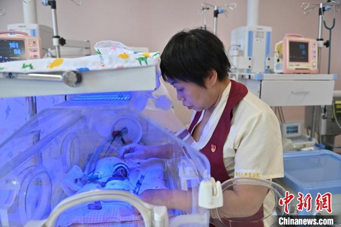 护士长高玉先在给照蓝光的小宝宝调整姿势。这里的护士就要担当他们的临时“奶爸奶妈”的角色。　张瑶 摄